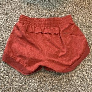 Athleta shorts in orange geo print with mesh detail and side pocket